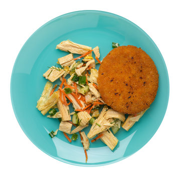 fishcake with soy asparagus and carrots, cucumbers and dilll.  fish cutlet on a plate isolated. cutlet with vegetables top view
