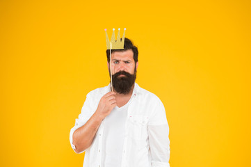 Photo booth fun. Bearded man king costume party. Handsome bearded guy king. King of party. Costume party. Holiday carnival celebration. Birthday boy. Guy in yellow background posing with booth props