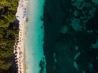 Aerial view of turquoise water of Balearic sea and green nature at  Formentor beach, Palma de Mallorca island, Spain. People relax on the beach. Summertime, time to travel, relax and wellness 