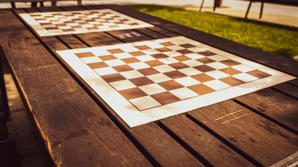 empty chess board outdoors on wooden table