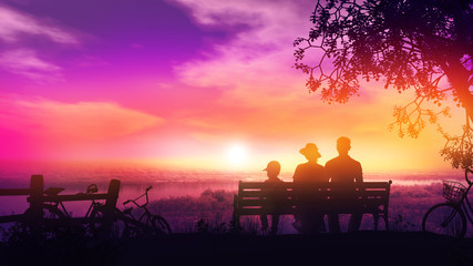 Family of three on a bench at sunset and a beautiful view of the river