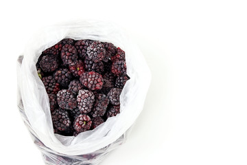 Frozen organic blackberry located in transparent package on awhite background, horizontal orientation, copy space