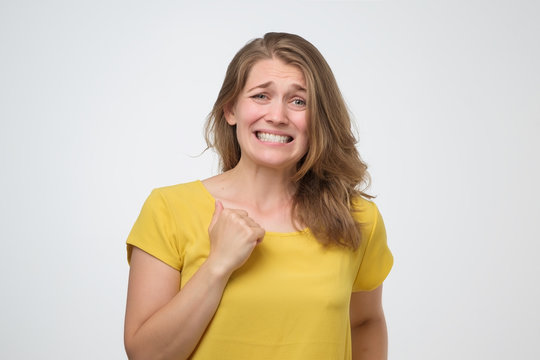 Woman Feeling Awkward, Looking With Weird Smile After Making Mistake And Being Guilty