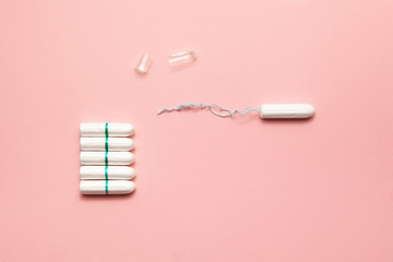 Unpacked tampons on a soft pink background. Modern female intimate gynecological hygiene. Eco zero waste concept. Copy spase place for text. Flat lay