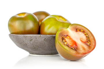 Group of three whole one half of fresh greenish red tomato on grey ceramic plate isolated on white background