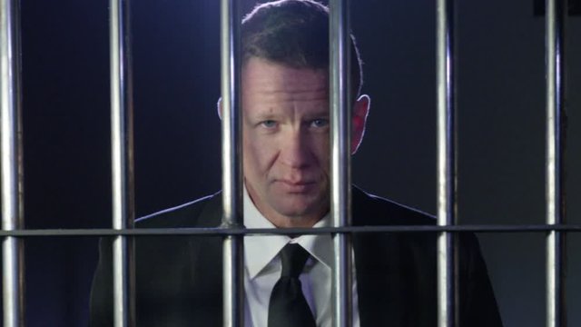 White collar criminal in jail behind bars