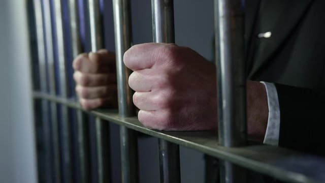 White collar criminal in jail behind bars