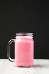 Raspberry smoothie in a glass jar mug, side view. Close-up.