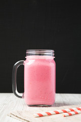 Raspberry smoothie in a glass jar mug, side view. Close-up.