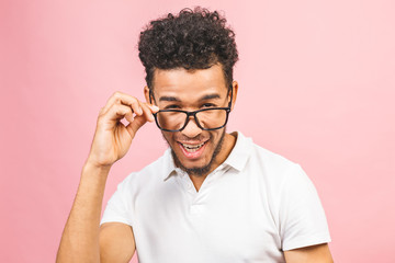 Soon to be startup owner or salesman. Portrait of cool and handsome african male student looking at camera smiling with eyeglasses isolated against pink background.