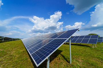 Solar panel on blue sky background. Green grass and cloudy sky. Alternative sun energy concept