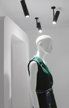 Close up of of plastic fashion mannequin dressed green dress. Design and fashion concept.