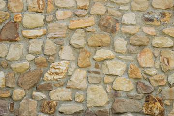 Stone wall with odd shaped rocks in shades of brown