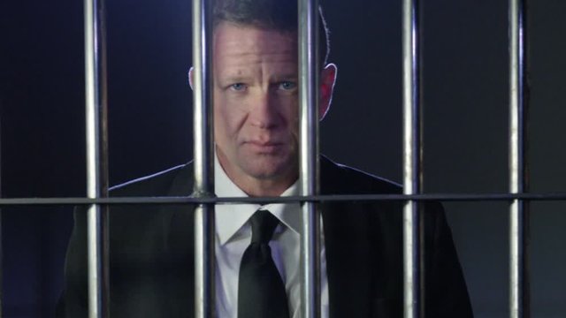 White collar criminal in jail behind bars