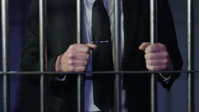 White collar criminal in jail behind bars
