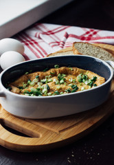 egg shaped casserole on the Board next to slices of bread