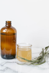 Amber Glass and Cup of Kombucha, Healthy Probiotic Drink, White and Marble Background, Copy Space
