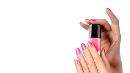 Beautiful Hands with Perfect Shiny Pink Manicure Holding Nail Polish Lacqueron White Background. Copy Space