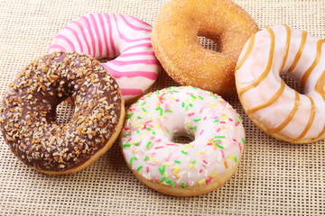 assorted delicious homemade doughnuts in the glaze, colorful sprinkles and nuts .