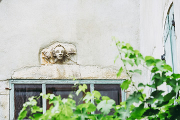 Visage sculpté dans la pierre au dessus d'une fenêtre