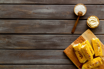 Fried corn on board with salt and butter on wooden background top view mockup
