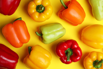 Flat lay composition with ripe bell peppers on yellow background