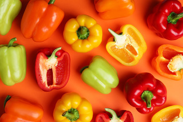 Flat lay composition with ripe bell peppers on orange background