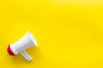 Attract attention with megaphone on yellow background top view copyspace