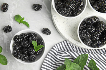 Fototapeta na wymiar Flat lay composition of tasty blackberries on grey marble table