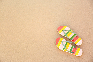 Fototapeta na wymiar Stylish flip flops on sand, top view with space for text. Beach accessories