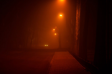 Foggy misty night in the city illuminated by street lights