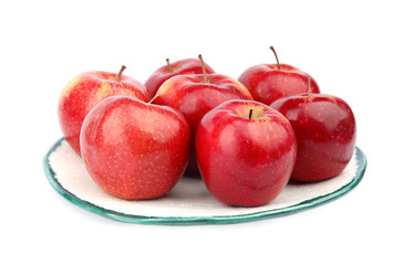 Plate of ripe juicy red apples on white background