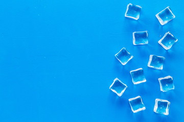 Fototapeta na wymiar ice cubes on blue table top view mock up