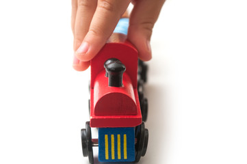 Naklejka premium Closeup of hand of kid playing with wooden train on white background