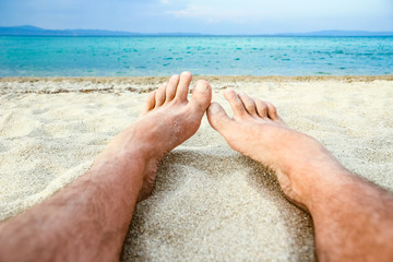beautiful legs in the sand of the sea greece background
