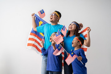 proud malaysian family holding malaysia flag over white background on independence day