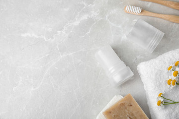 Flat lay composition with natural crystal alum deodorant and space for text on light grey marble table