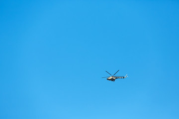 Fototapeta na wymiar Modern military helicopter flying in blue sky