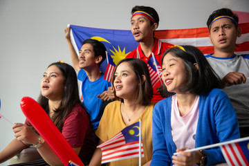 malay group of people holding malaysia flag celebrating independence day