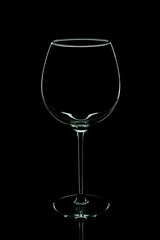 Elegant silhouette empty wine glass isolated on black background. Alcohol drinking concept.