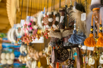 trinkets, national ornaments and amulets hang in a specialized shop on the market for sale