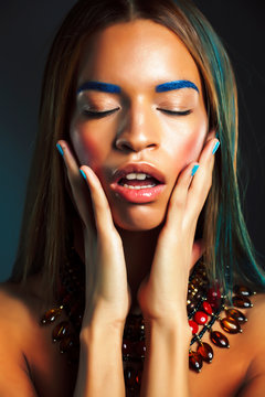 young pretty modern african american girl with bright fashion makeup and ethnic jewelry
