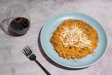 pumpkin peas risotto with parmesan topping on concrete table