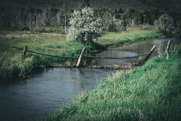 Broken Farm Fence Crossing River