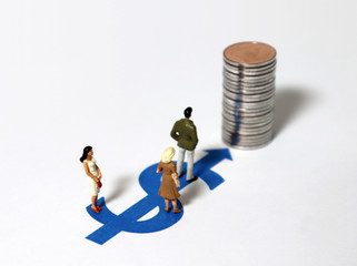 Miniature people standing on the dollar symbol with a pile of coins.