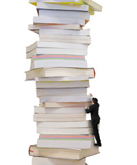 Reading and learning a mountain of new knowledge concept. Businessman climbing on high stack of books, isolated on white background.