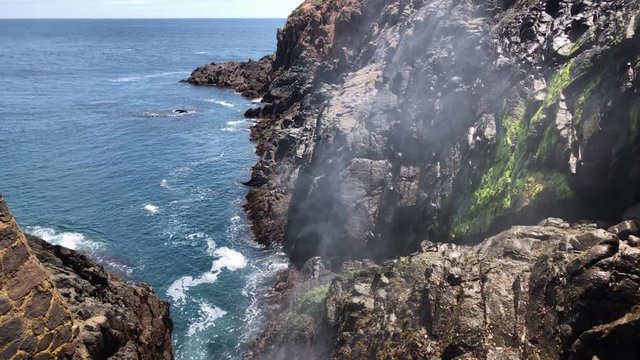 Horizontal Slow Motion steady shot clip of the Ensenada, Mexico Bufadora also known as blowhole or geyser, expulsing water through the mountains and rocks.