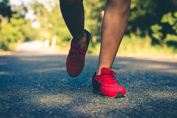 Plakat Close up foot women run feet on road in workout wellness.