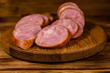 Cutting board with sliced sausage on a wooden table