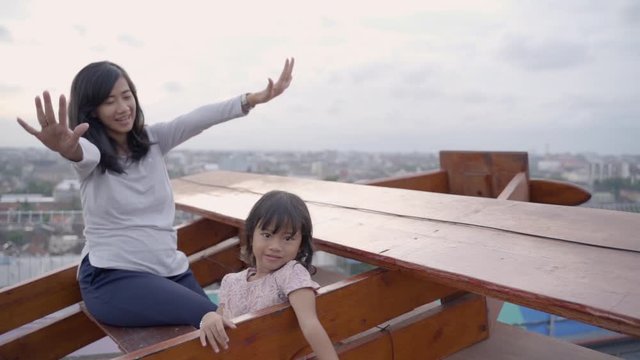 mother invited her daughter to play along with the movements imitating the plane